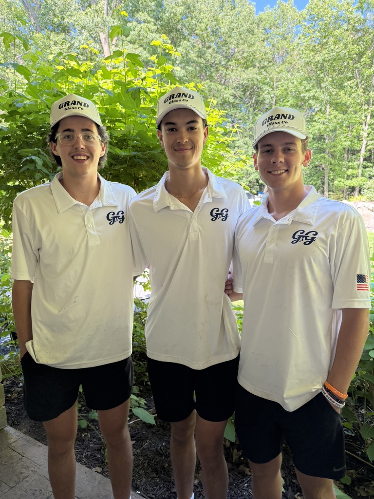 Three Grand Glass Co team members in white polos and branded hats
